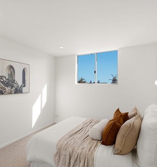 Bright, modern bedroom with white walls and large window showing blue sky.