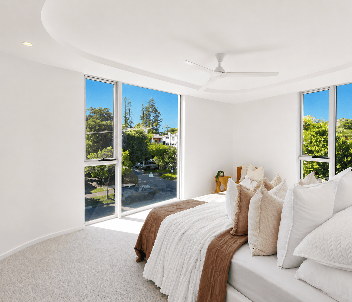 Bright modern bedroom with large windows and scenic outdoor views.