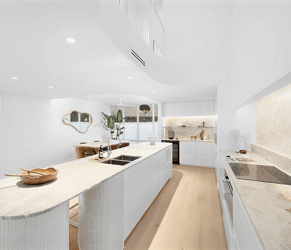 Modern white kitchen with marble countertops and minimalist design.
