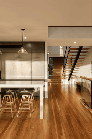 Modern interior with wooden flooring, staircase, and dining area.