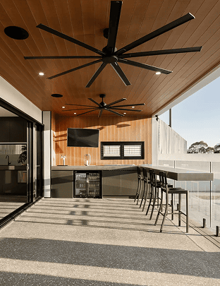 Modern outdoor balcony with ceiling fans and bar seating under a wooden ceiling.