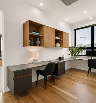 Modern home office with wooden wall shelves and a sleek desk setup.