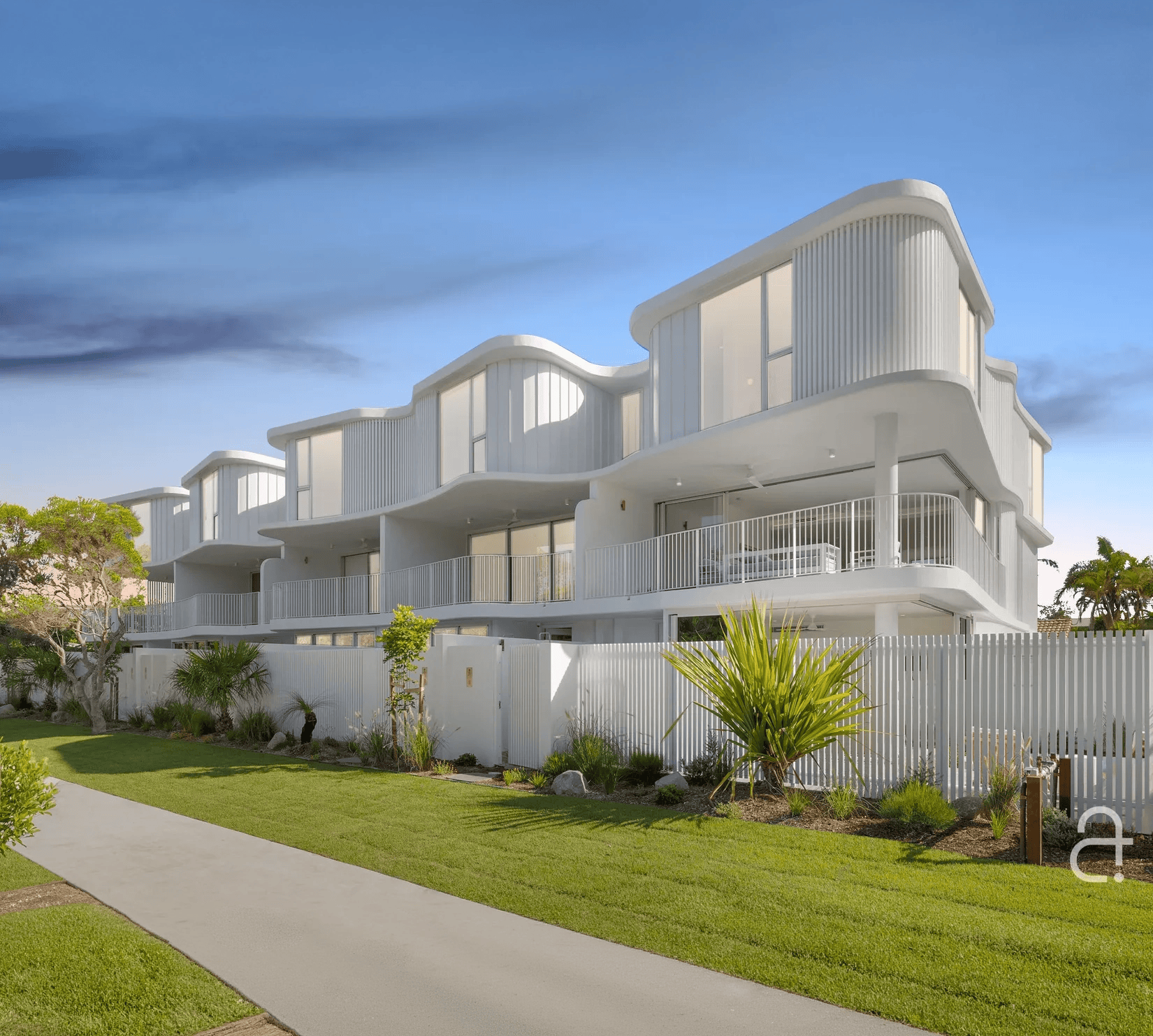 Contemporary white apartment complex with curved balconies in Warana.