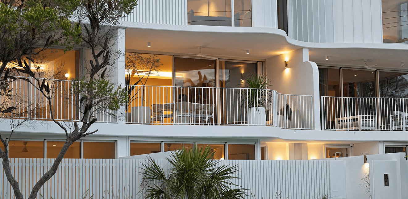 Modern multi-storey residential building with balconies and large glass windows.